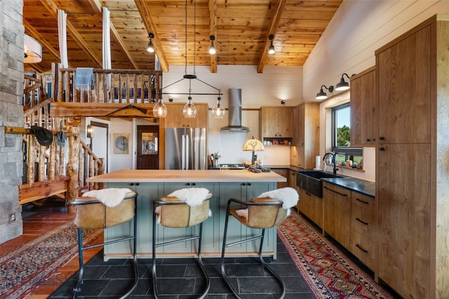 125 Rocky Mountain Mdws, Bozeman, MT 59715 - kitchen with freestanding refrigerator, wooden ceiling with exposed beams, a sink, wall chimney range hood, and a center island