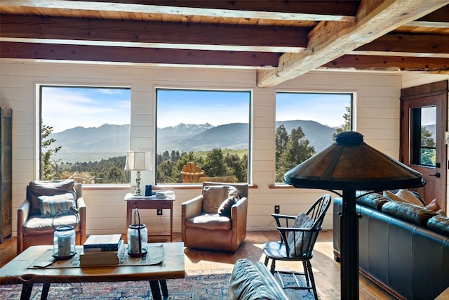 125 Rocky Mountain Mdws, Bozeman, MT 59715 - living area featuring a mountain view, wood-type flooring, healthy amount of natural light, wood ceiling with exposed beams, and wood walls