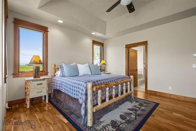 306 Glenbrook Ln, Belgrade, MT 59714 - bedroom with baseboards, wood finished floors, recessed lighting, a tray ceiling, and a ceiling fan