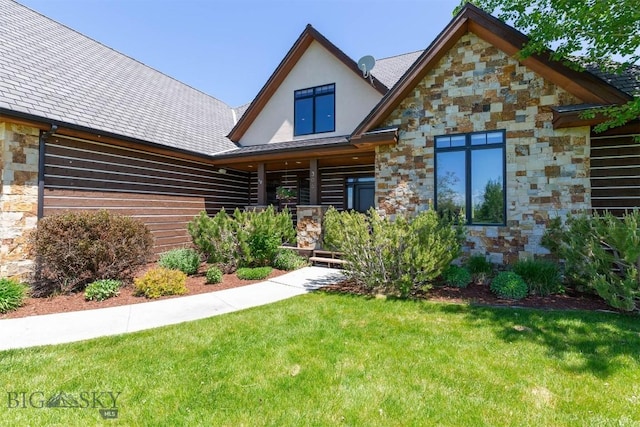 306 Glenbrook Ln, Belgrade, MT 59714 - view of front facade featuring stone siding, a front yard, a porch, and stucco siding
