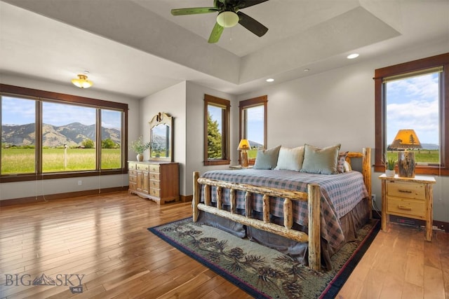 306 Glenbrook Ln, Belgrade, MT 59714 - bedroom with hardwood / wood-style floors, a raised ceiling, baseboards, recessed lighting, and a mountain view