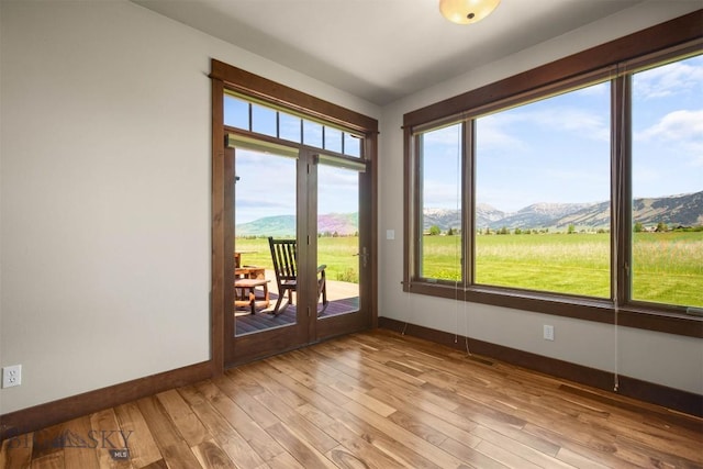 306 Glenbrook Ln, Belgrade, MT 59714 - unfurnished room featuring a mountain view, baseboards, light wood finished floors, and plenty of natural light
