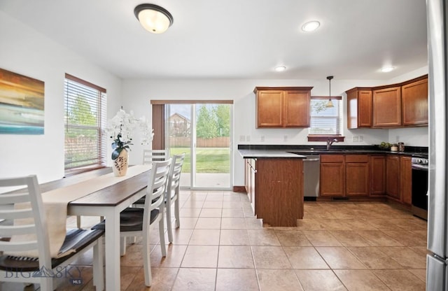 4068 Opal St, Bozeman, MT 59718 - kitchen with dark countertops, stainless steel appliances, brown cabinets, a sink, and pendant lighting