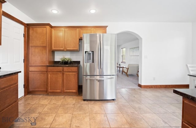 4068 Opal St, Bozeman, MT 59718 - kitchen featuring stainless steel refrigerator with ice dispenser, arched walkways, brown cabinetry, light tile patterned floors, and recessed lighting