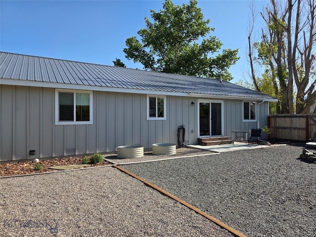 108 E 9th Ave, Twin Bridges, MT 59754 - rear view of house with board and batten siding, a patio, metal roof, and entry steps