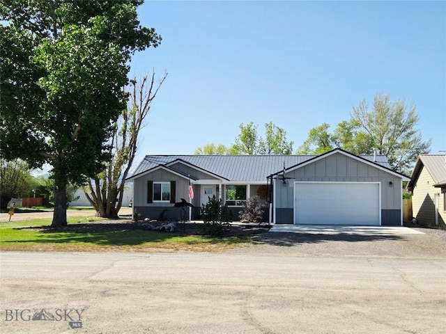 108 E 9th Ave, Twin Bridges, MT 59754 - ranch-style house with driveway, board and batten siding, an attached garage, and a front yard
