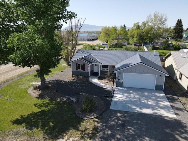 108 E 9th Ave, Twin Bridges, MT 59754 - single story home with driveway, metal roof, board and batten siding, a front yard, and a garage