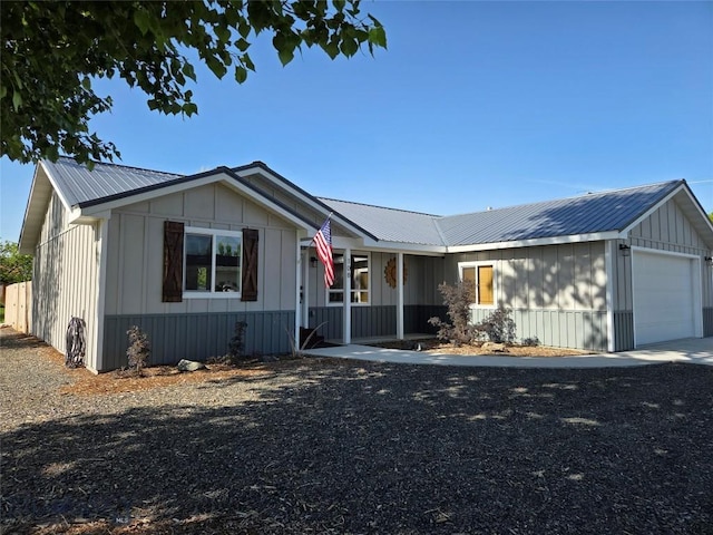 108 E 9th Ave, Twin Bridges, MT 59754 - view of front of house featuring an attached garage, board and batten siding, metal roof, and a porch