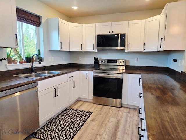 108 E 9th Ave, Twin Bridges, MT 59754 - kitchen featuring stainless steel appliances, butcher block counters, a sink, light wood-style flooring, and white cabinets