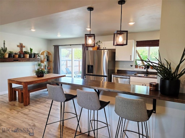 108 E 9th Ave, Twin Bridges, MT 59754 - kitchen with stainless steel appliances, dark countertops, a sink, white cabinets, and a kitchen bar