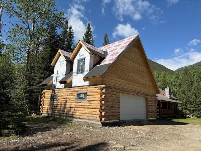 14 Ken Dan, Mcleod, MT 59052 - view of property exterior with log siding, driveway, a detached garage, and a chimney