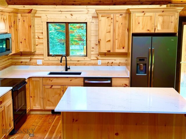 14 Ken Dan, Mcleod, MT 59052 - kitchen featuring appliances with stainless steel finishes, a sink, light brown cabinetry, wood walls, and light wood finished floors