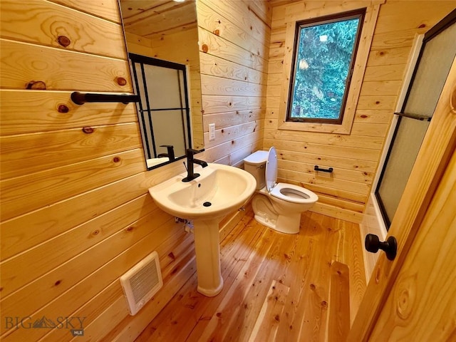 14 Ken Dan, Mcleod, MT 59052 - bathroom featuring wood walls, toilet, hardwood / wood-style flooring, a sink, and an enclosed shower