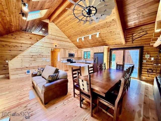 14 Ken Dan, Mcleod, MT 59052 - dining area featuring wood ceiling with exposed beams, a skylight, light wood-type flooring, high vaulted ceiling, and wooden walls
