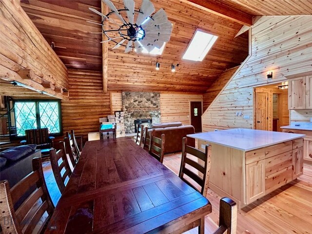 14 Ken Dan, Mcleod, MT 59052 - dining area featuring light wood-style floors, wooden ceiling with exposed beams, high vaulted ceiling, a skylight, and a fireplace