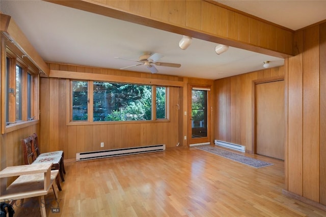 1524 S Grand, Bozeman, MT 59715 - empty room featuring a baseboard heating unit, light wood-type flooring, wood walls, and ceiling fan