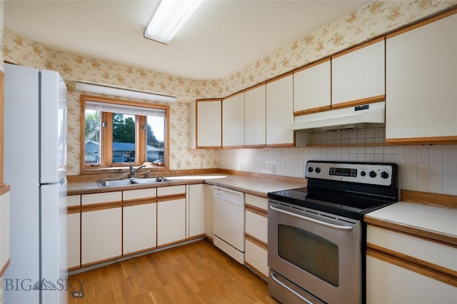 1524 S Grand, Bozeman, MT 59715 - kitchen featuring white appliances, under cabinet range hood, a sink, wallpapered walls, and light wood-style flooring