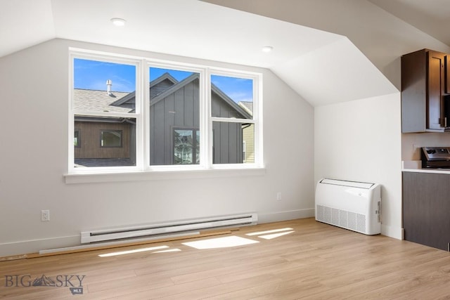 4149 Annie St, Bozeman, MT 59718 - additional living space with a baseboard radiator, vaulted ceiling, light wood-type flooring, plenty of natural light, and baseboards