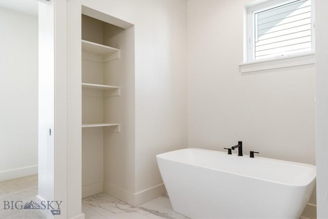 4149 Annie St, Bozeman, MT 59718 - bathroom with a freestanding bath, marble look tile flooring, and baseboards