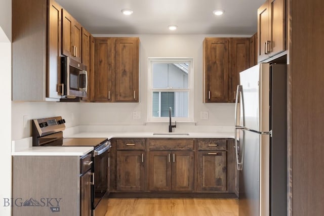 4149 Annie St, Bozeman, MT 59718 - kitchen with appliances with stainless steel finishes, a sink, light countertops, light wood-type flooring, and recessed lighting