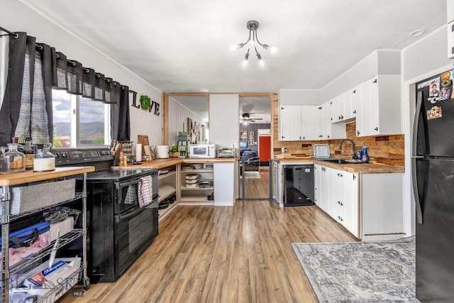 3101 Paxson, Butte, MT 59701 - kitchen featuring black appliances, a sink, light wood-type flooring, and white cabinets