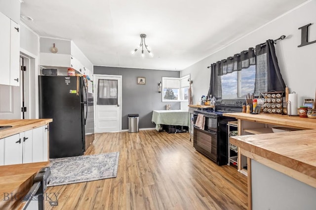 3101 Paxson, Butte, MT 59701 - kitchen with butcher block countertops, black appliances, light wood-style flooring, and white cabinetry