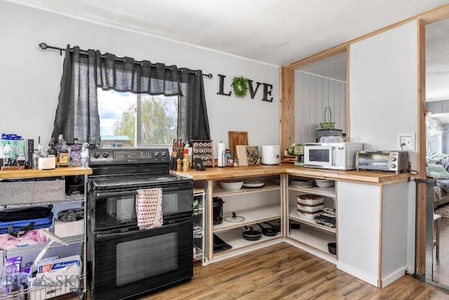 3101 Paxson, Butte, MT 59701 - kitchen with black range with electric stovetop, butcher block countertops, white microwave, wood finished floors, and open shelves