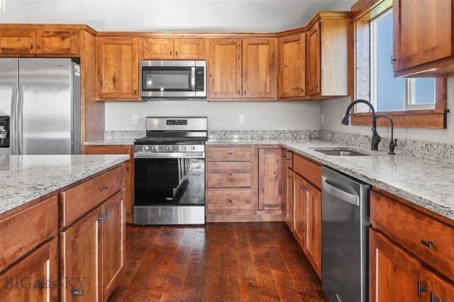 9 Murray Ln, Three Forks, MT 59721 - kitchen featuring appliances with stainless steel finishes, brown cabinetry, light stone counters, and dark wood-style flooring