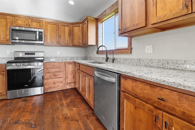 9 Murray Ln, Three Forks, MT 59721 - kitchen with appliances with stainless steel finishes, brown cabinets, light stone counters, and dark wood-style floors