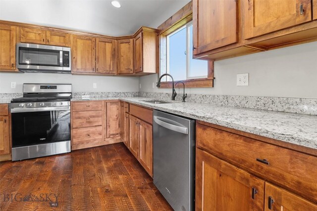 9 Murray Ln, Three Forks, MT 59721 - kitchen with appliances with stainless steel finishes, brown cabinets, light stone counters, and dark wood-style flooring