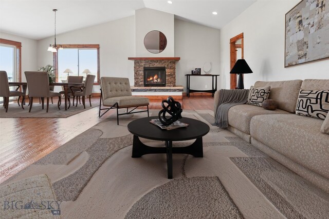 9 Murray Ln, Three Forks, MT 59721 - living area with wood finished floors, vaulted ceiling, a stone fireplace, recessed lighting, and a chandelier