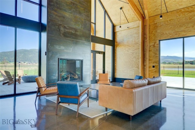 529 Clancy Way, Bozeman, MT 59718 - living area with a towering ceiling, finished concrete flooring, a mountain view, and a tile fireplace