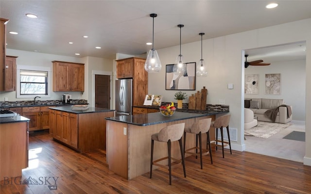 45 Spain Bridge Circle Dr, Belgrade, MT 59714 - kitchen featuring freestanding refrigerator, dark wood-type flooring, a sink, a peninsula, and brown cabinets