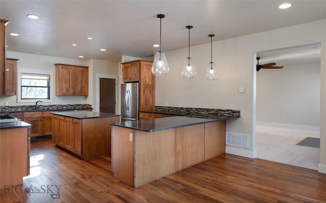 45 Spain Bridge Circle Dr, Belgrade, MT 59714 - kitchen with freestanding refrigerator, a sink, dark wood-style flooring, a center island, and recessed lighting