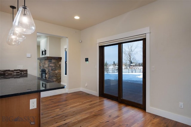 45 Spain Bridge Circle Dr, Belgrade, MT 59714 - unfurnished dining area featuring wood finished floors, baseboards, a stone fireplace, and recessed lighting