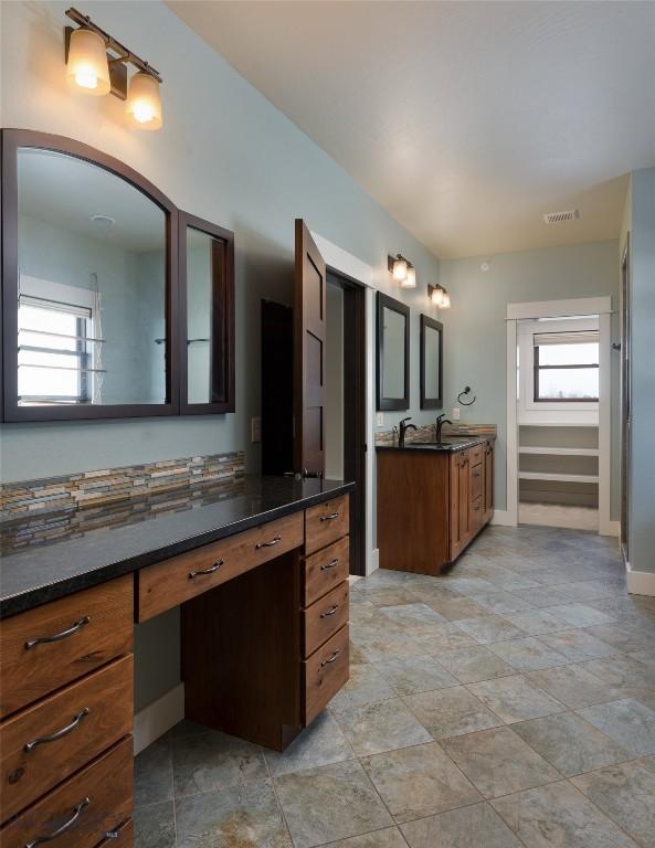 45 Spain Bridge Circle Dr, Belgrade, MT 59714 - full bath featuring two vanities, baseboards, and stone finish floors