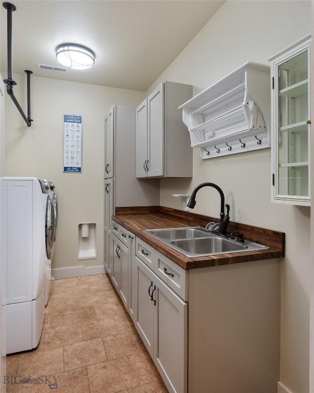 45 Spain Bridge Circle Dr, Belgrade, MT 59714 - washroom with cabinet space, washer and dryer, and baseboards