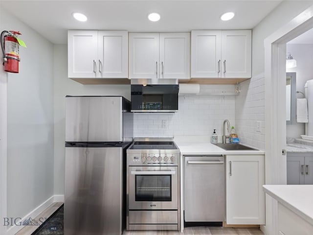21 Sitting Bull Rd Unit 1190, Big Sky, MT 59716 - kitchen with stainless steel appliances, a sink, white cabinetry, light countertops, and recessed lighting