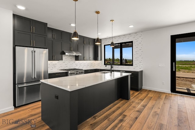 2939 S 30th Ave, Bozeman, MT 59718 - kitchen with high end refrigerator, a sink, light stone counters, under cabinet range hood, and backsplash