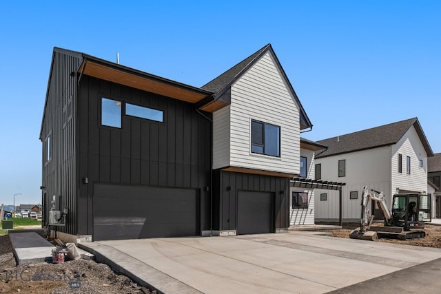2939 S 30th Ave, Bozeman, MT 59718 - view of front of house with board and batten siding, an attached garage, and driveway