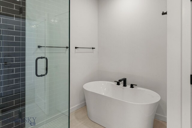 2939 S 30th Ave, Bozeman, MT 59718 - bathroom featuring a shower stall, a freestanding bath, and baseboards