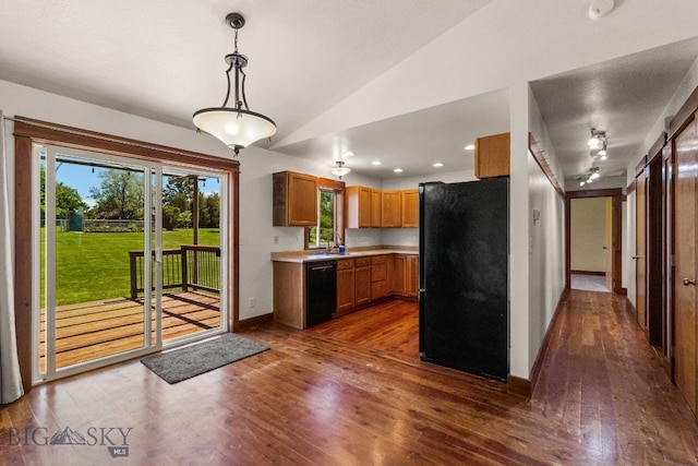 370 Prospector, Bozeman, MT 59718 - kitchen featuring black appliances, dark wood-style floors, light countertops, lofted ceiling, and brown cabinets