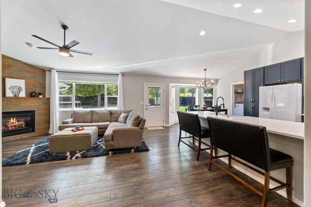 3194 Oliver St, Bozeman, MT 59718 - living room with vaulted ceiling, a glass covered fireplace, dark wood-type flooring, a chandelier, and a ceiling fan