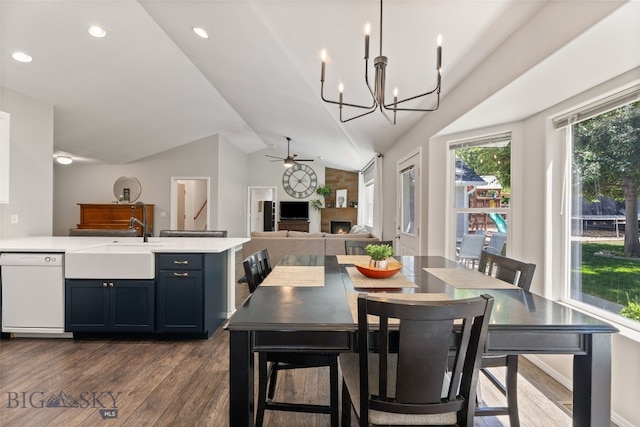 3194 Oliver St, Bozeman, MT 59718 - dining space with dark wood-style flooring, ceiling fan, vaulted ceiling, a lit fireplace, and a chandelier