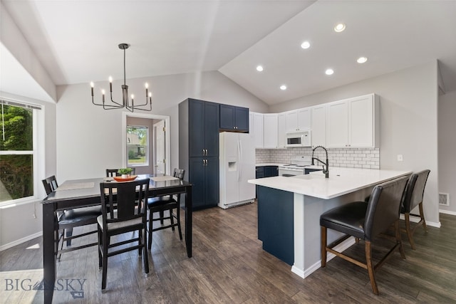 3194 Oliver St, Bozeman, MT 59718 - kitchen featuring white appliances, a peninsula, vaulted ceiling, a chandelier, and light countertops