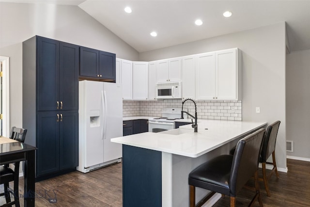 3194 Oliver St, Bozeman, MT 59718 - kitchen with white appliances, a peninsula, a kitchen breakfast bar, dark wood-style flooring, and backsplash