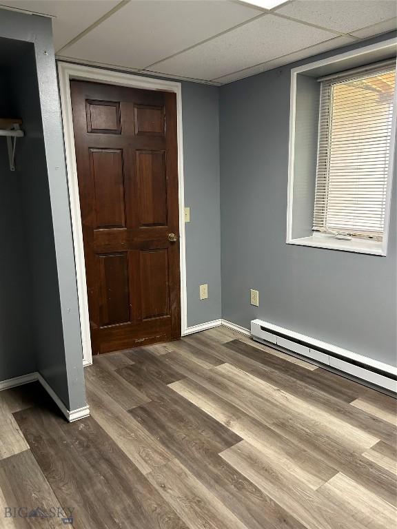 1106 Caledonia St, Butte, MT 59701 - unfurnished bedroom featuring dark wood-type flooring, baseboards, and baseboard heating