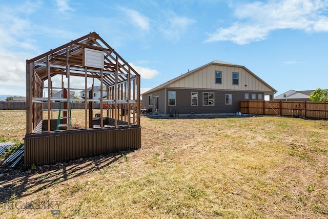 1165 Stewart Loop, Bozeman, MT 59718 - back of house with board and batten siding, a greenhouse, and an outdoor structure
