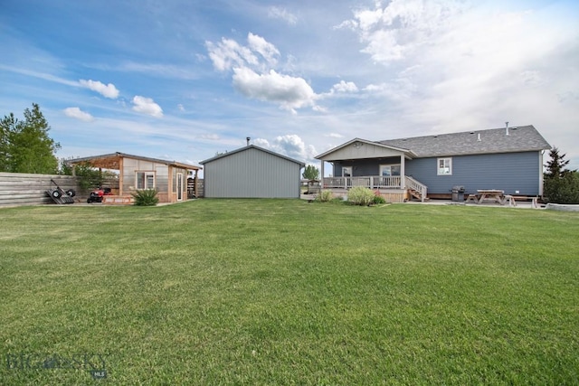 191 Barnes Dr, Belgrade, MT 59714 - rear view of house with a deck, an outbuilding, a lawn, and roof with shingles