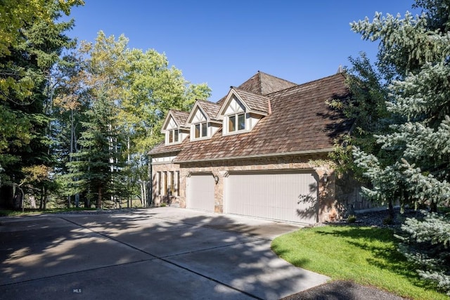 2421 Highland Blvd, Bozeman, MT 59715 - view of home's exterior featuring concrete driveway, stone siding, and an attached garage